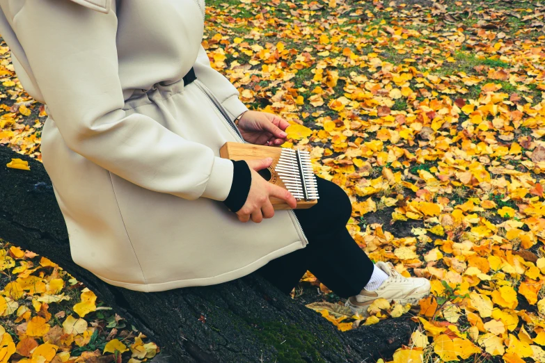 a woman sits on a bench in the leaves