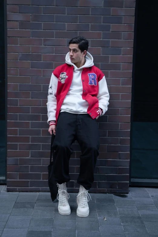 a man stands in front of a brick wall