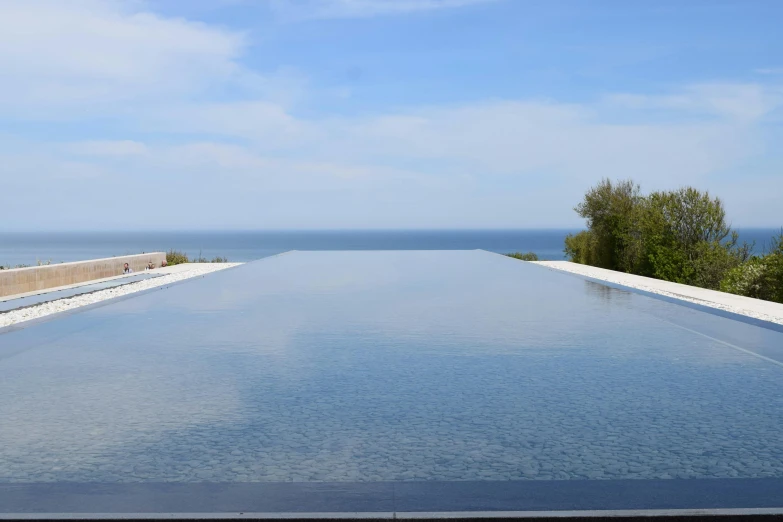 an empty pool with the ocean in the background