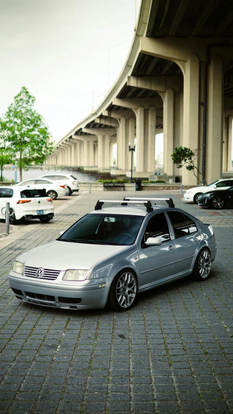 a silver car is parked in front of an underpass