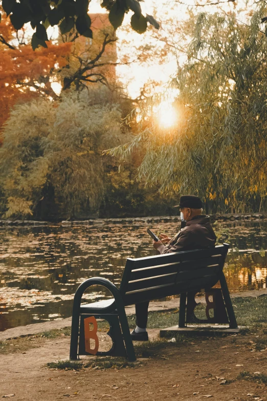 a man sits on a park bench using his phone