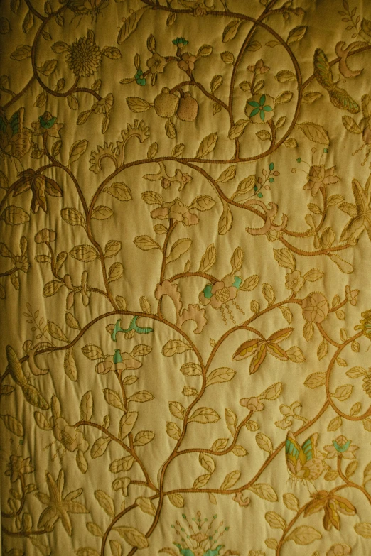 an intricate gold embroidered piece with leaves