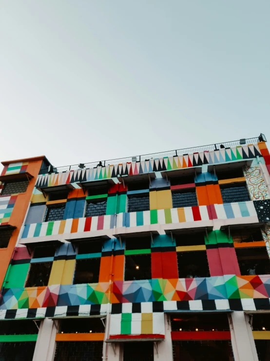 the multicolored building has an array of squares on it