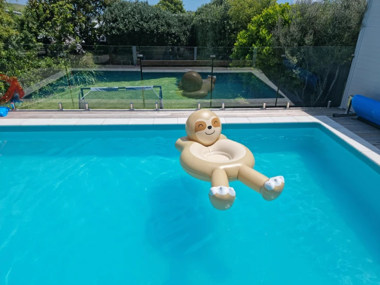 a pool with a large inflatable monkey swimming