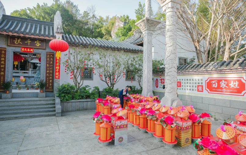 a woman standing in front of a building with orange lanterns