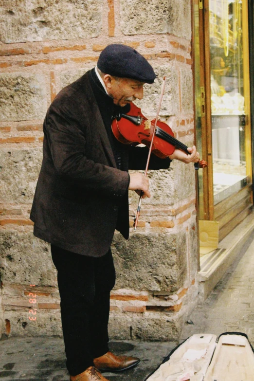 an older man playing the violin outside