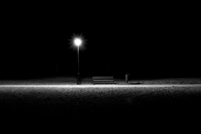 a bench in the dark on a street corner