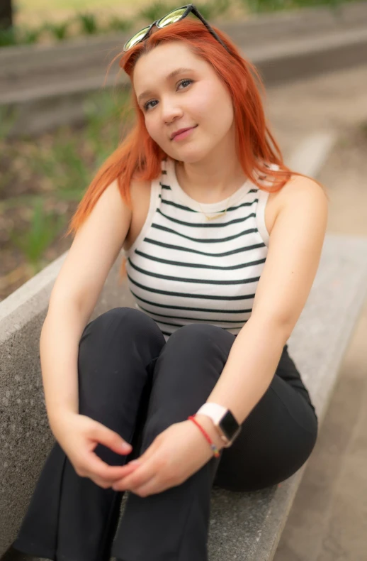 a  sitting on a cement block wearing sunglasses