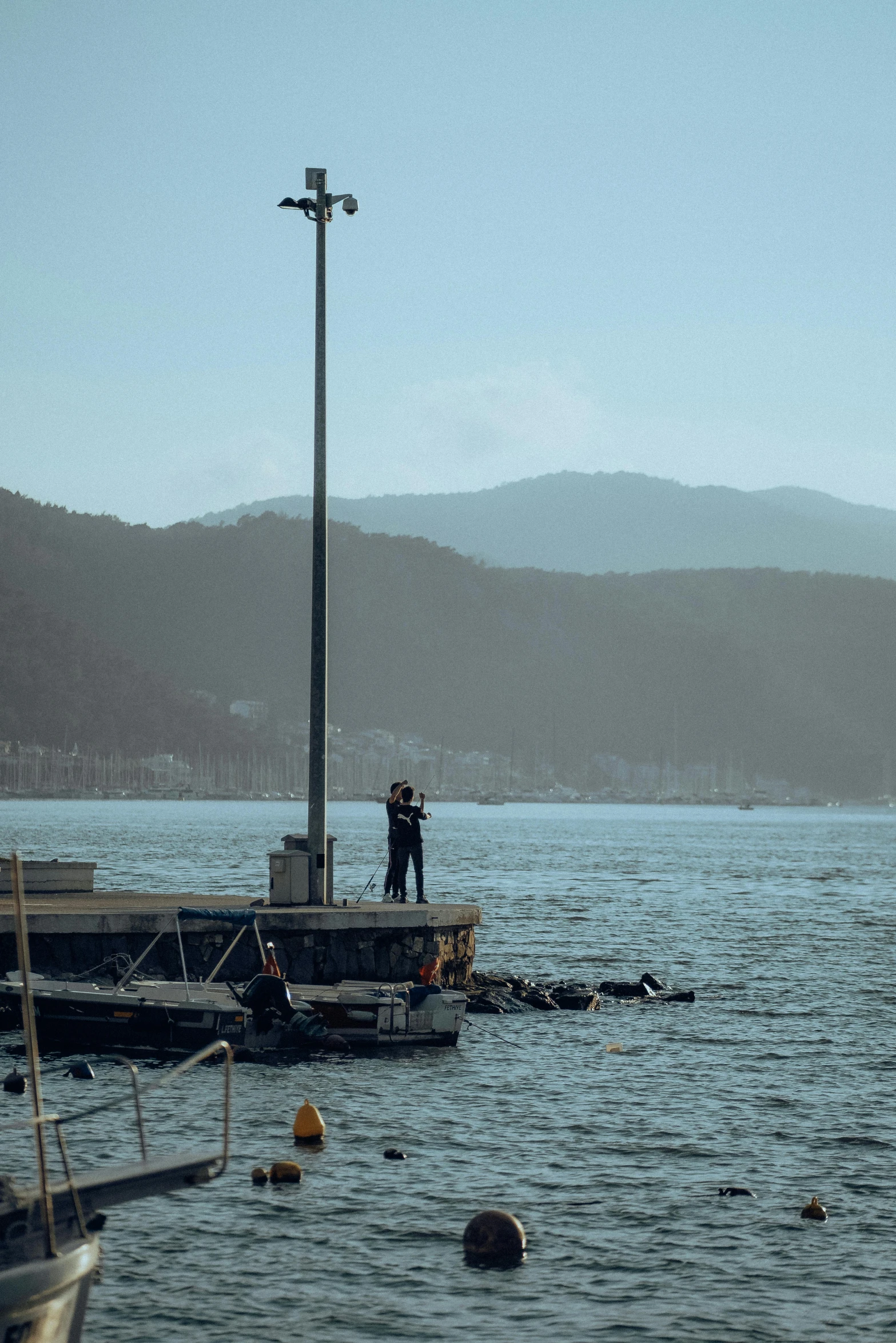 man on a pier using a cellular phone