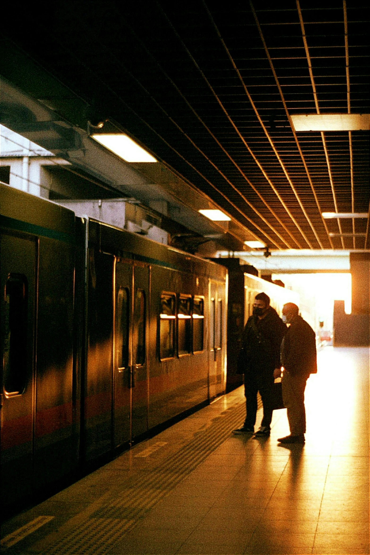 there are people standing by the doorway of the subway