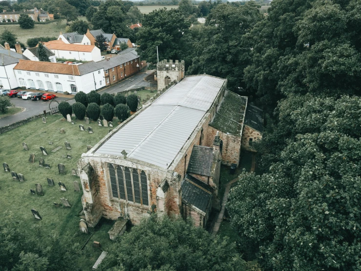 an aerial view of a church with green trees