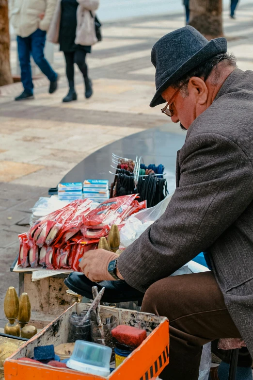 the old man is sitting on the table working on soing