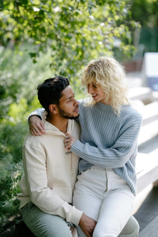 two people sitting together hugging in the middle of a walkway