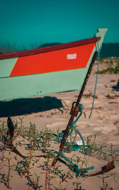 an old boat lies in the sand near a broken piece of wood