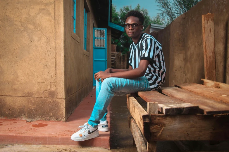 man wearing black and white striped shirt sitting on a bench