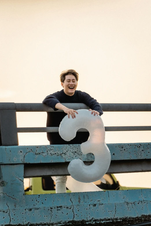 a man is on a wooden bench with a number 3 balloon