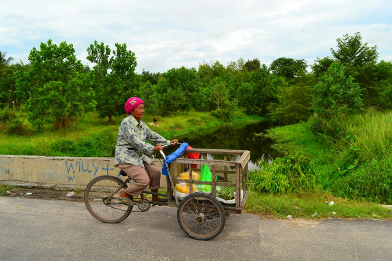 an african woman is riding her bicycle with bottles of water