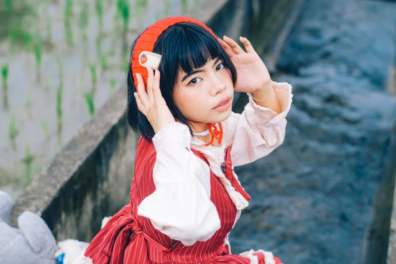 a young asian woman wearing headphones sitting down on the steps