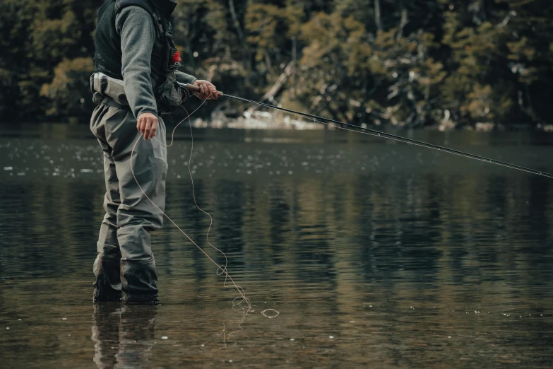 a man is standing in shallow water and fishing