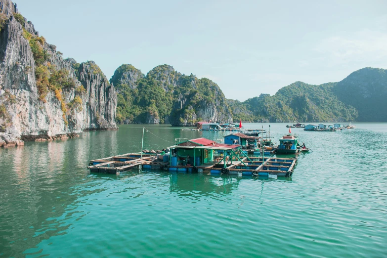 several boats float in the water near rocky cliffs