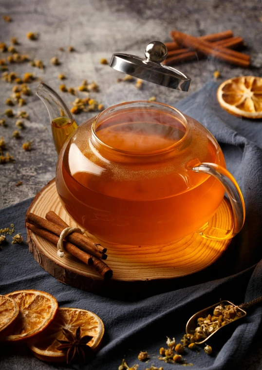 a tea pot filled with honey sitting on top of a wooden table