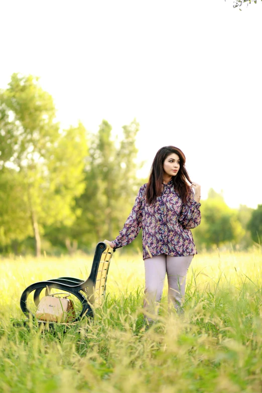 a woman is walking in a field with a backpack