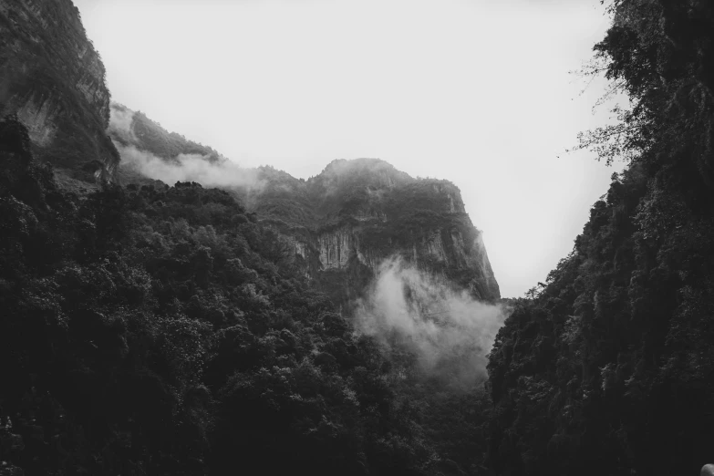 black and white pograph of mountains with mist on them