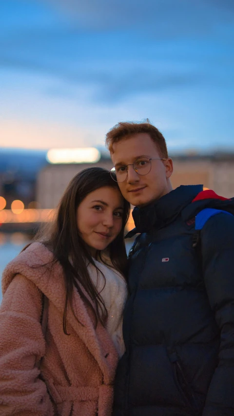 a man and woman standing in front of a water