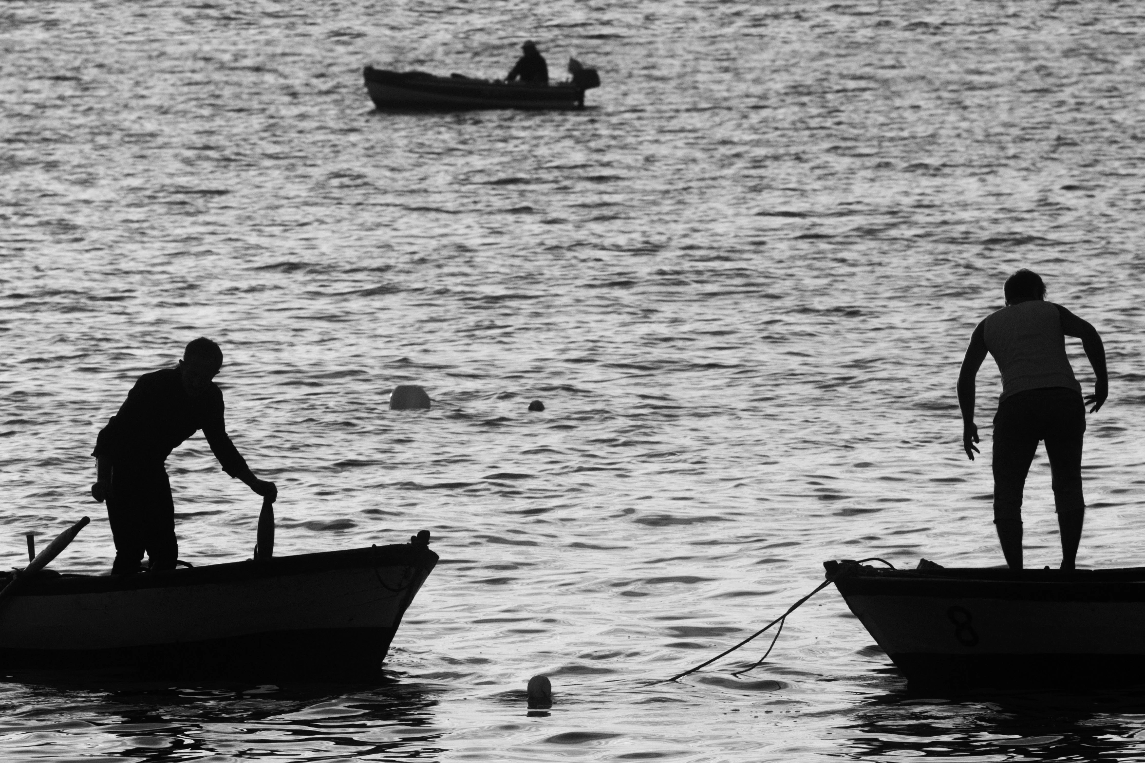 two people on small boats on the water