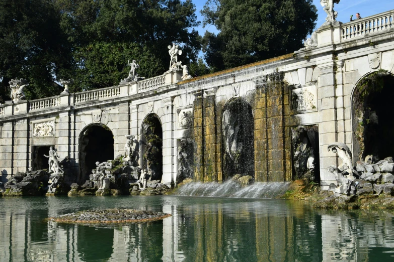 the fountain in front of a large stone wall