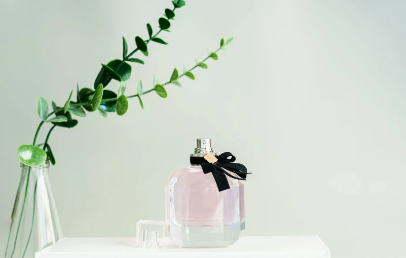 a vase of flowers with a black bow on a shelf