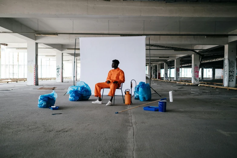 a person sitting on a chair with an orange outfit on