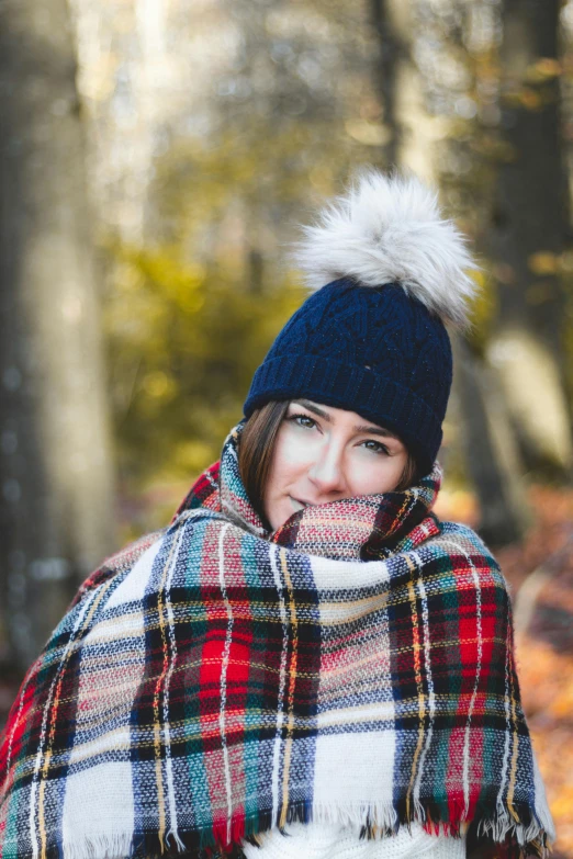 a woman wrapped up in a plaid blanket