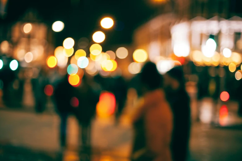 people are walking across the street at night