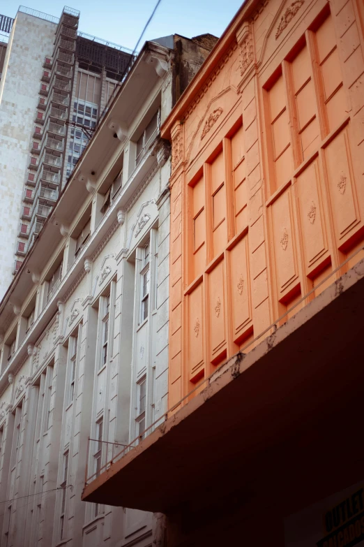 an orange and a grey building next to each other