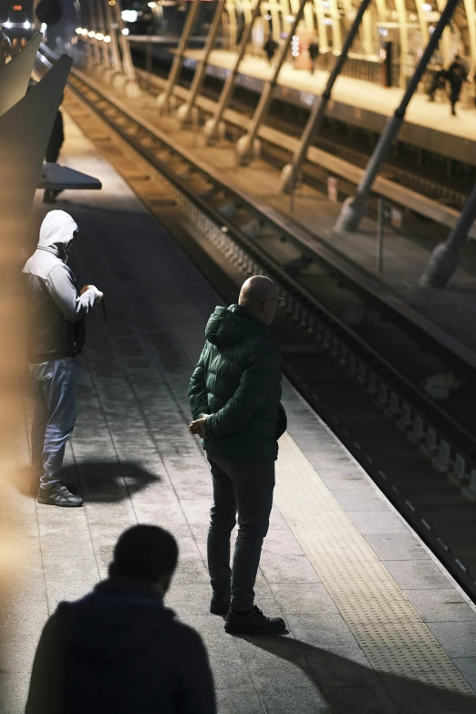 a man and woman are standing near a train station