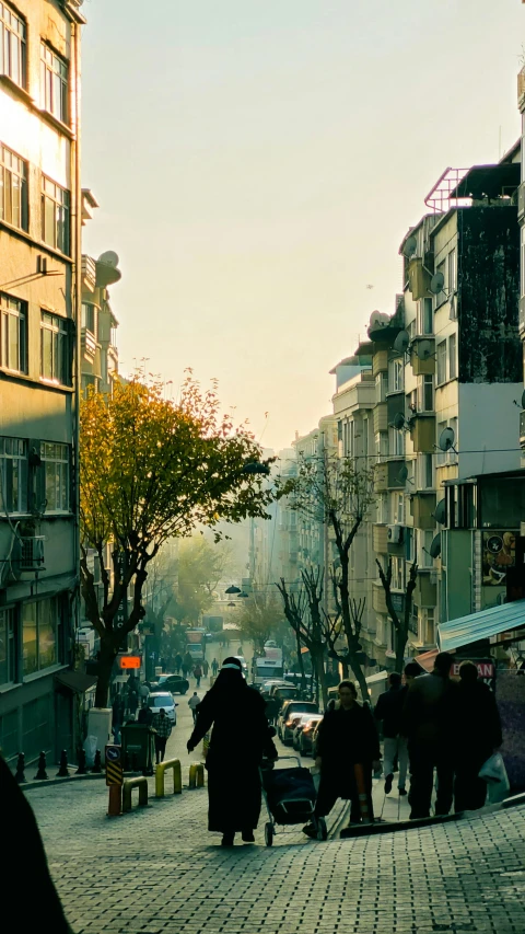 a city street with people walking around and parked cars on the side