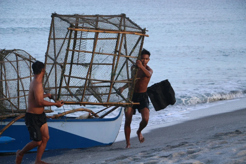two men with a net near the ocean