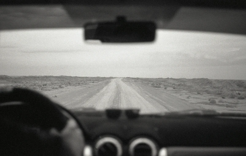 black and white po from inside car looking down the road