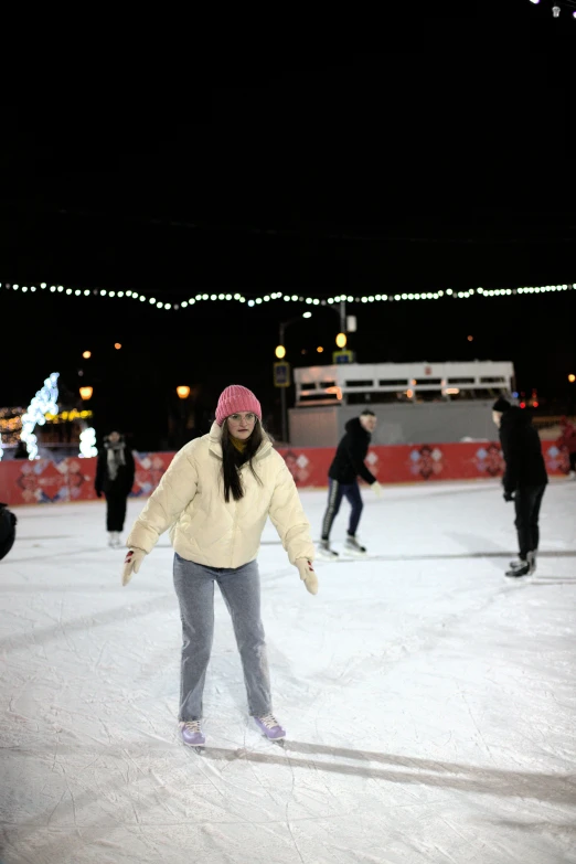 a woman on an ice rink skating with others around her