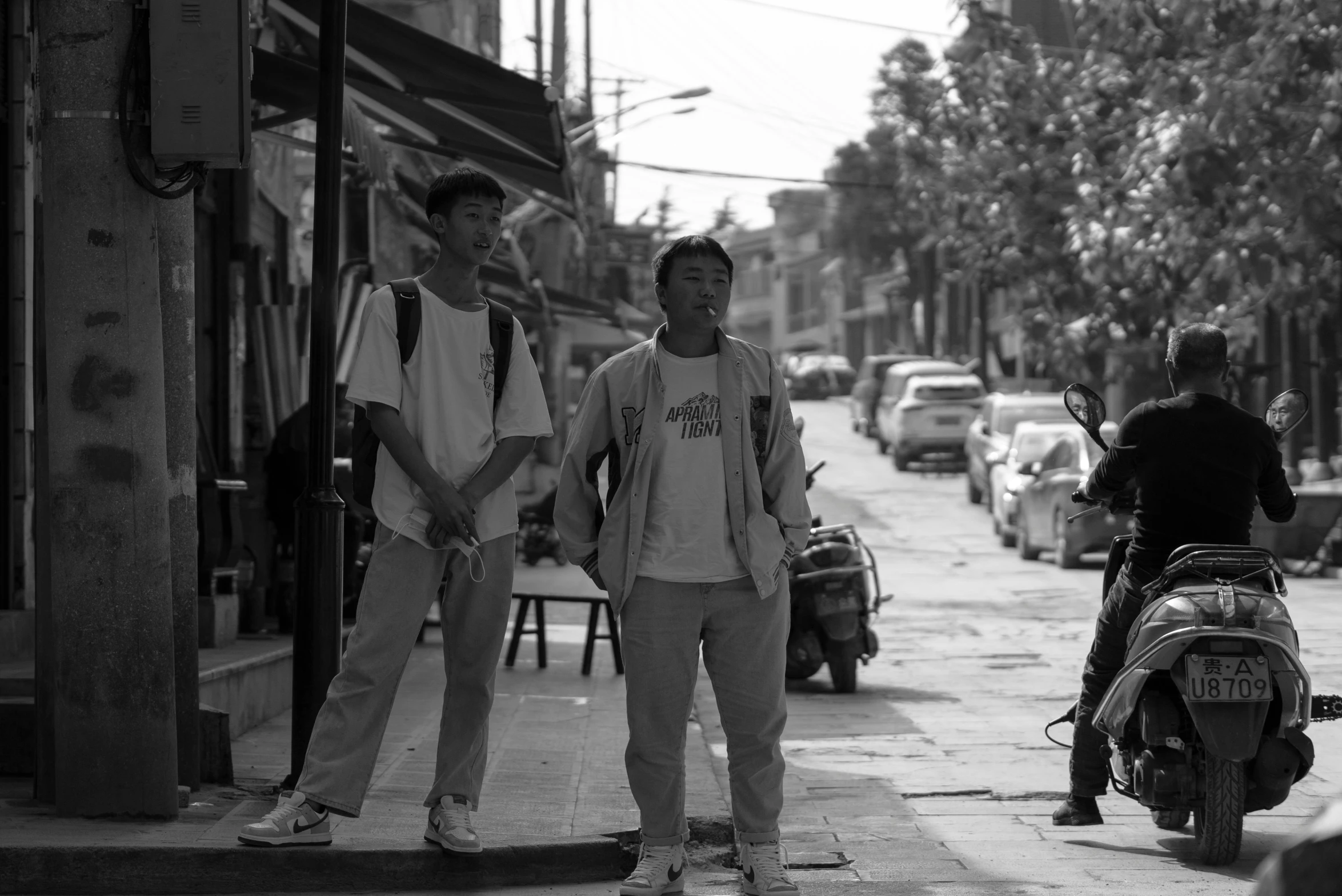 two men standing next to each other on a street