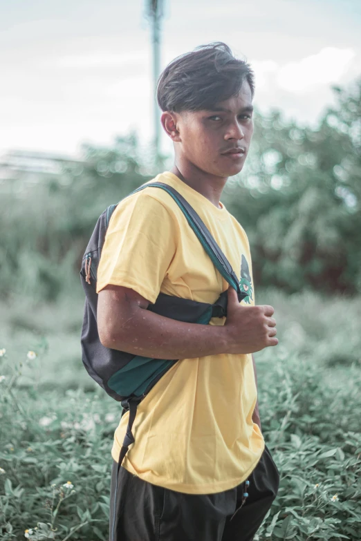 a boy carrying his backpack, holding his hand on his hip