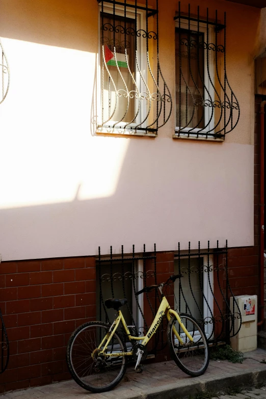 a bicycle parked outside of a home in front of a small window