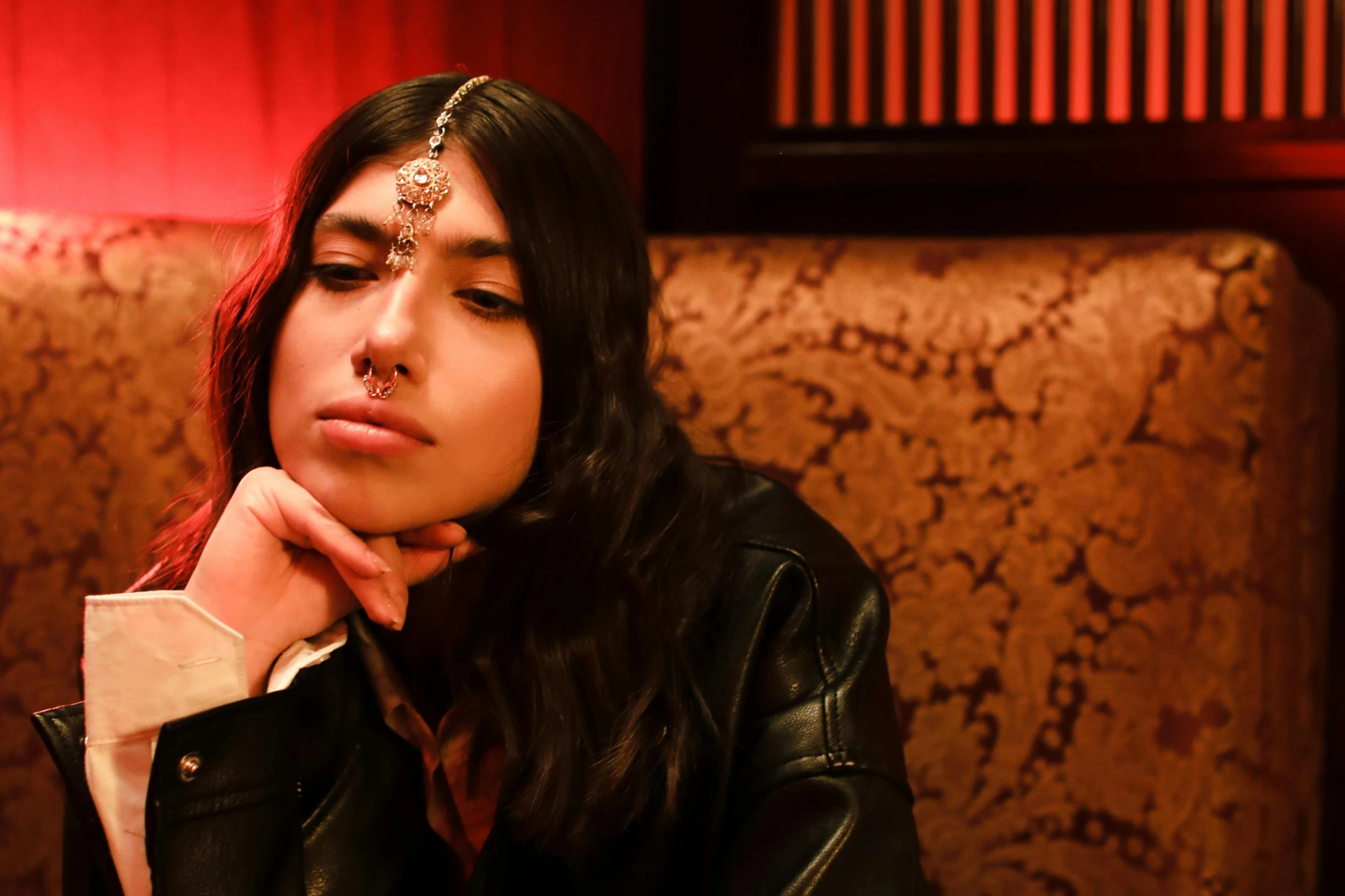 a girl sitting in front of the table with her hands under her chin