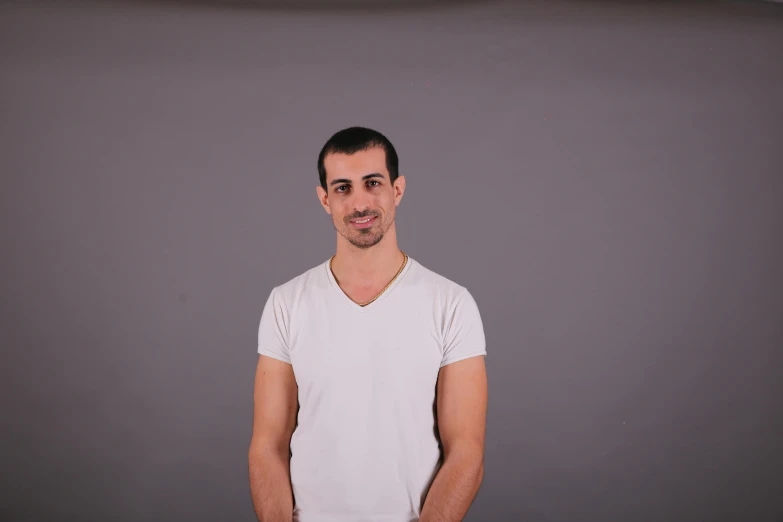 a man is smiling wearing a white shirt