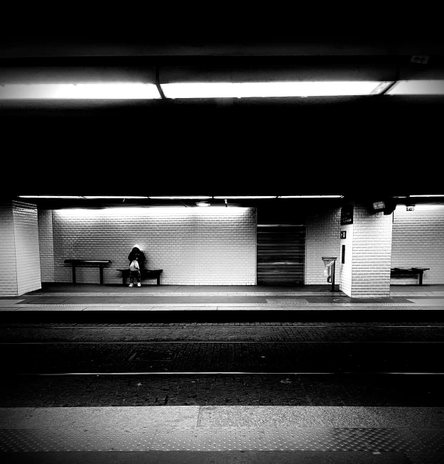 black and white pograph of a bench in a subway