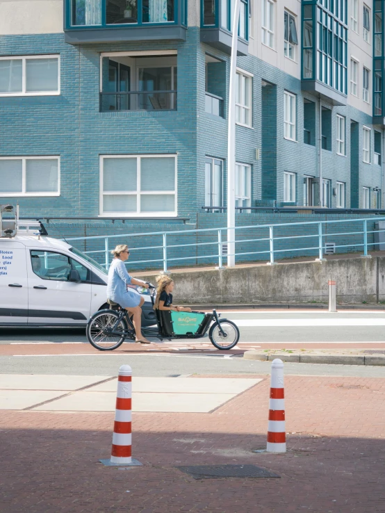 two people are riding a small bike on the street