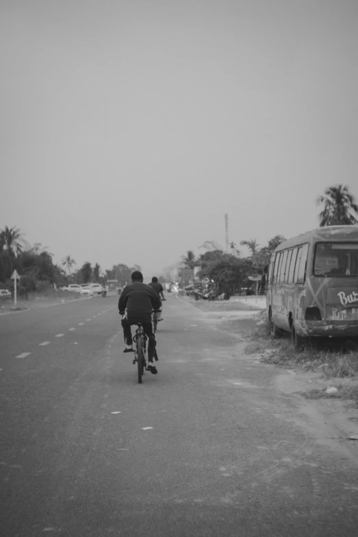 two people on bikes are riding down the road