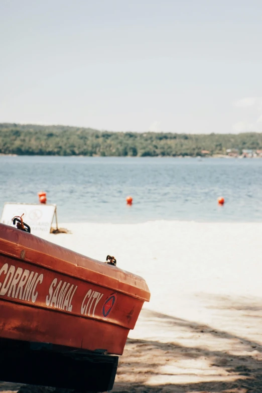 an orange boat sitting on a sandy beach