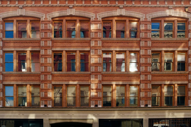 a large building with many windows and people standing near